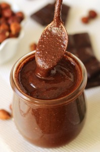 spoon digging into jar of hazelnut butter with chocolate