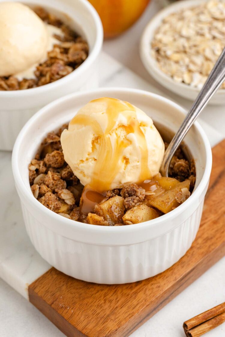 caramel topped ice cream on top of a ramekin filled with apple crumble
