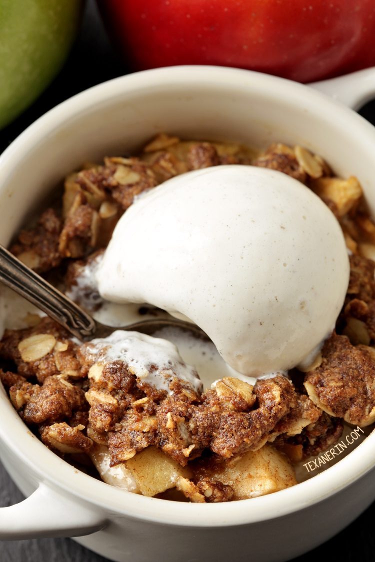 Spoon digging into a gluten-free apple crumble in a white ramekin