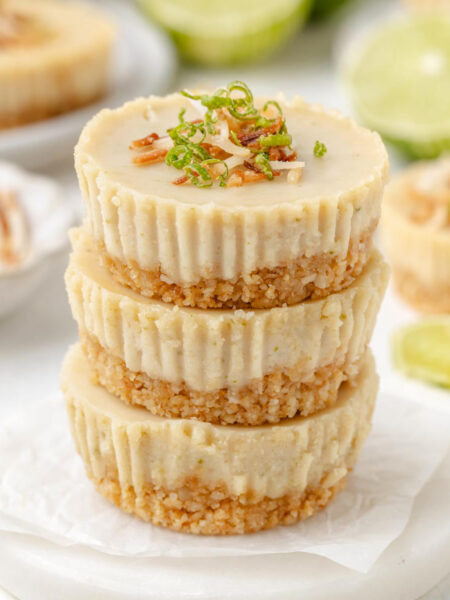 3 vegan key lime pies stacked on top of each other on a white table