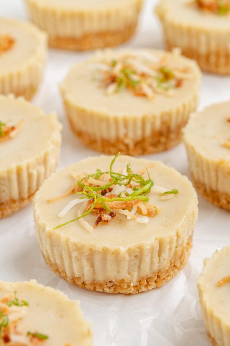 several vegan paleo no-bake lime pies on a white table with coconut on top
