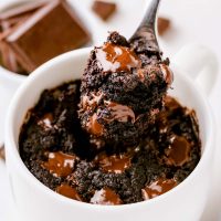 ramekin with spoon digging out a bite of vegan mug brownie