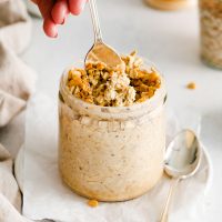 container of pb2 overnight oats with a spoon digging in