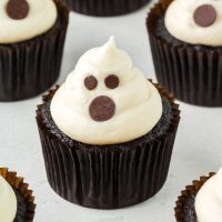 a cream cheese ghost piped on top of a cupcake
