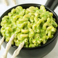 a toy skeleton hand on a black dish of halloween mac and cheese