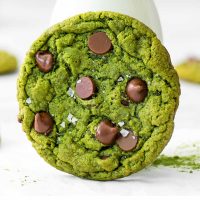 close up image of a vibrant green matcha cookie with chocolate chips and flecks of sea salt