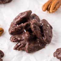 close-up of pecan cluster with salt flakes and toasted pecans in the background