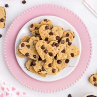 image of heart chocolate chip cookies stacked on a cute pin rimmed plate