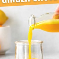 pin image with a glass bottle full of turmeric ginger shots being poured into a small glass jar with text stating benefits of ginger shots
