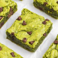 Image of a piece of matcha brownies that are green with chocolate chips.