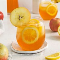 photo of a glass of refreshing apple lemonade garnished with lemon and apple slices