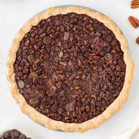 overhead view of a flaky gluten-free pie crust filled with chocolate pecan pie filling