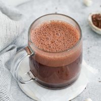 photo of a glass mug full of hot chocolate with frothed milk