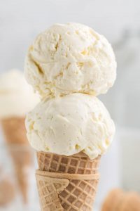 Close-up photo of two scoops of homemade French vanilla ice cream on a cone.