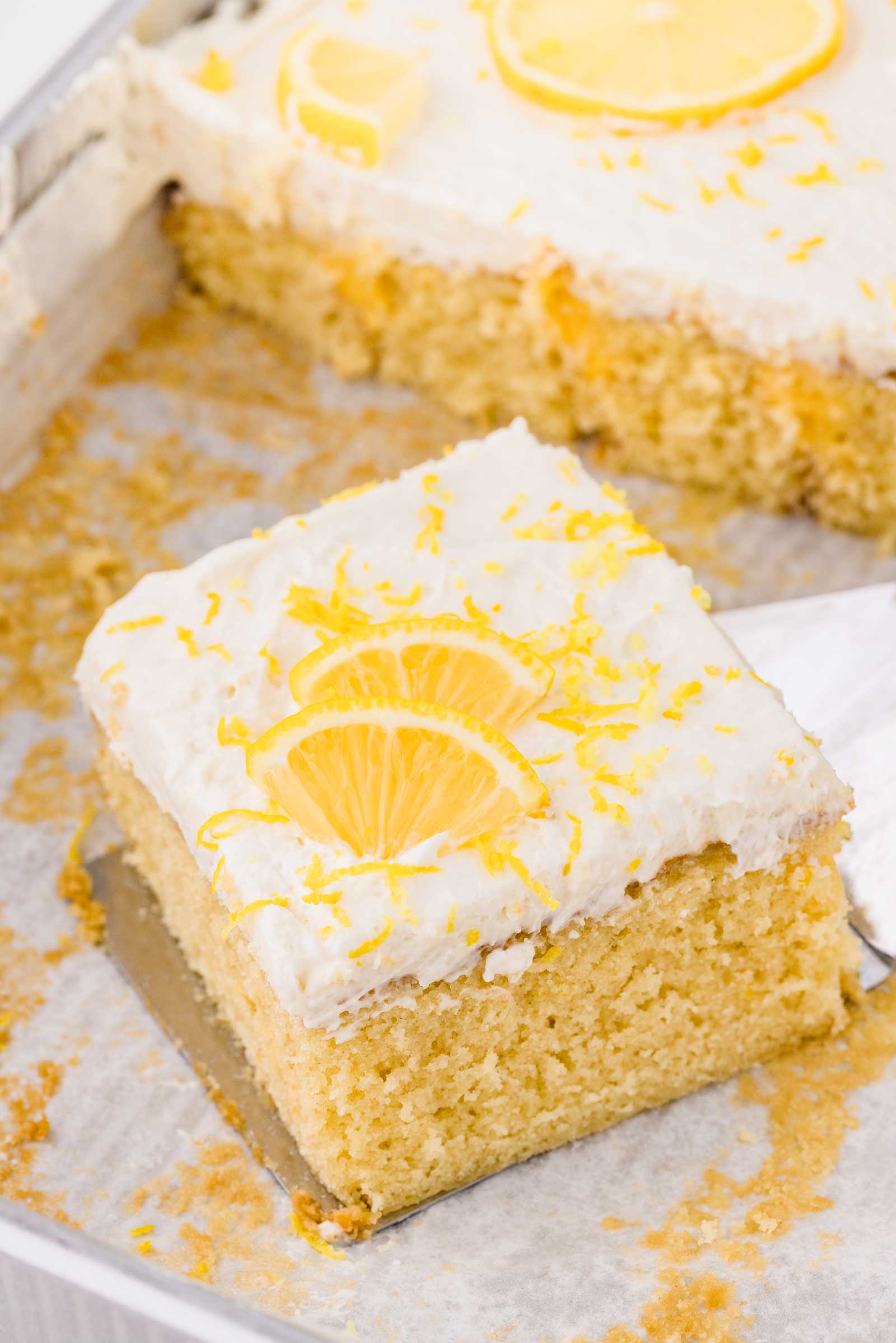 lemon curd cake with frosting and a lemon wedge
