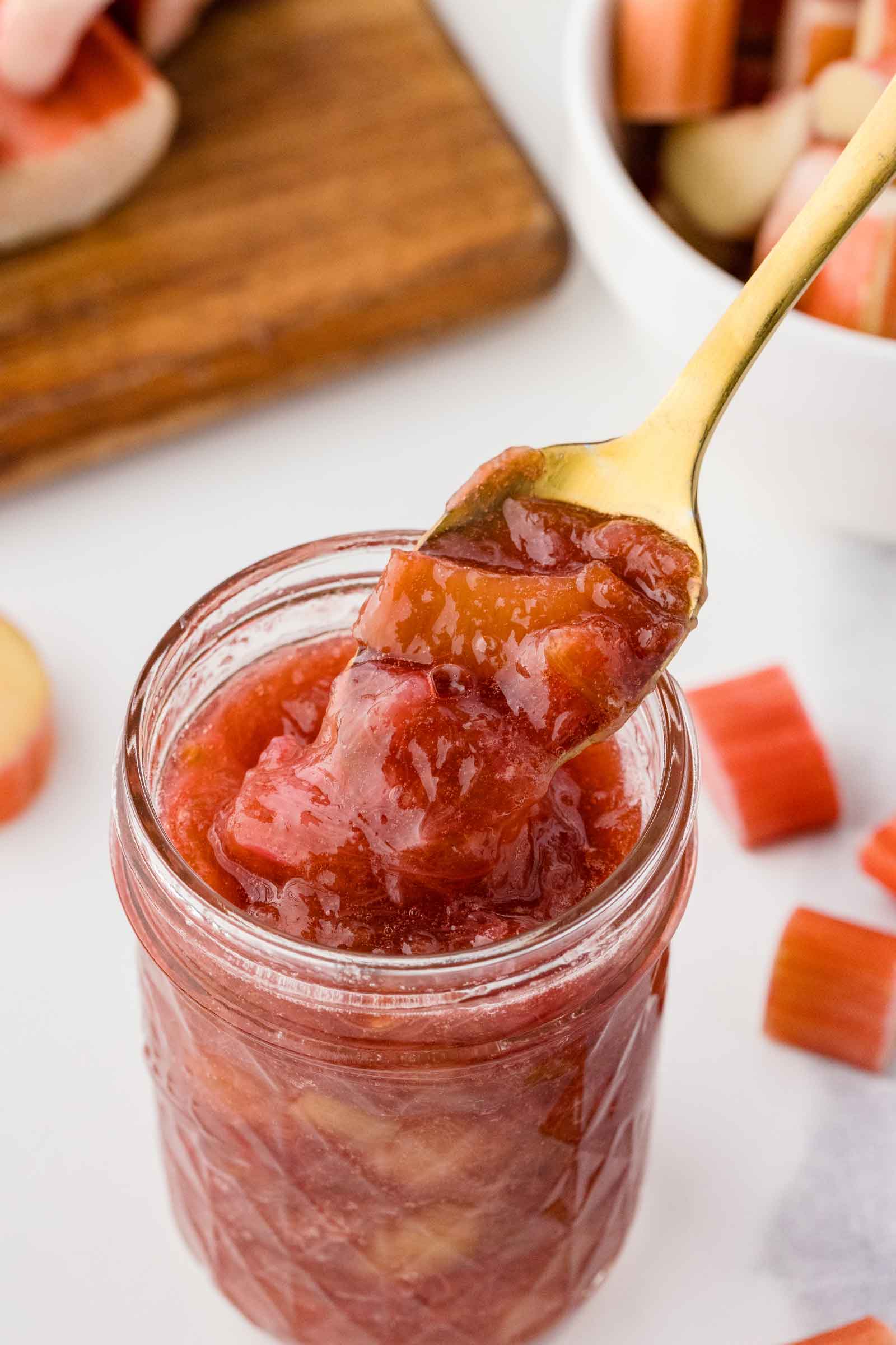 spoon digging into a jar of rhubarb preserves