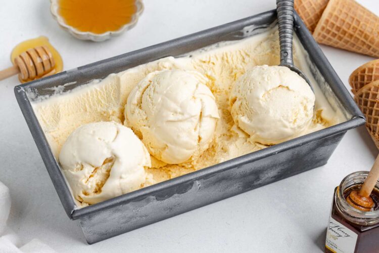 honey ice cream in a loaf pan with honey in background