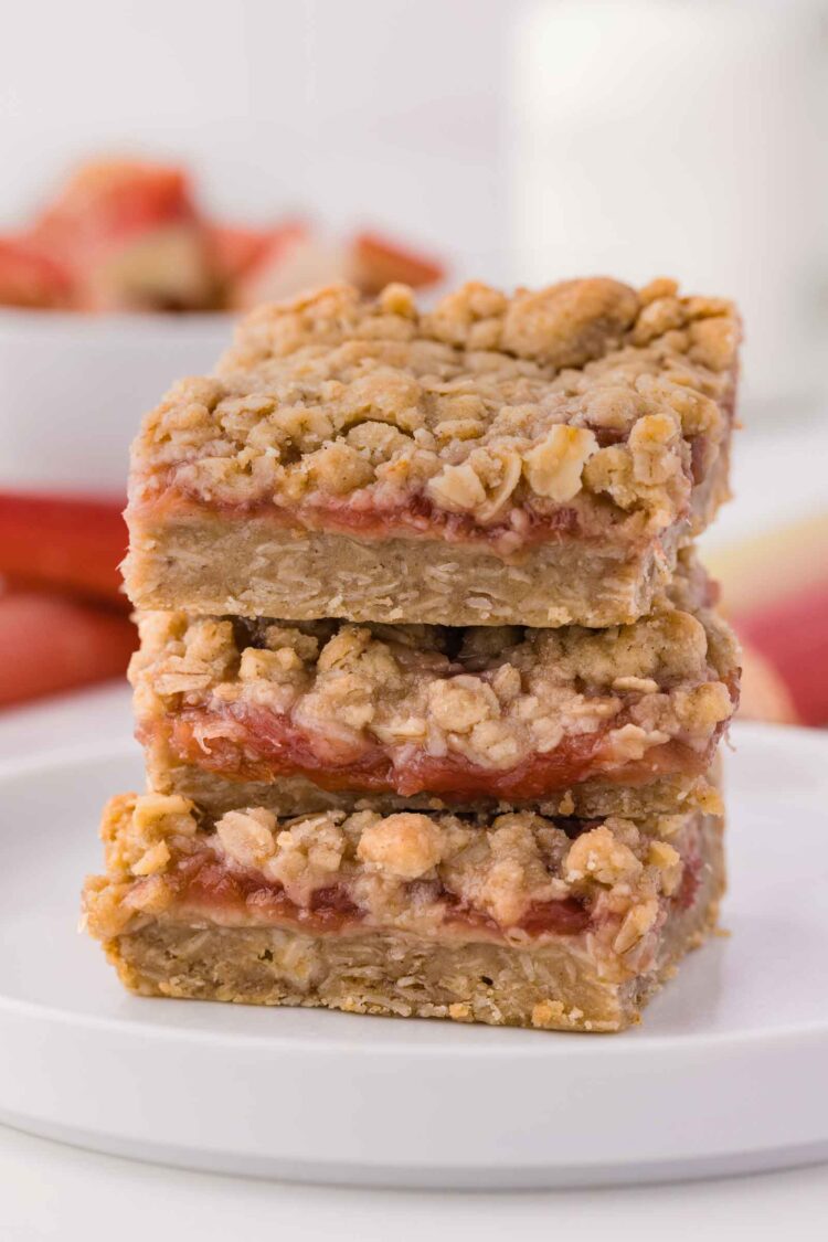 stack of rhubarb bars on a white plate on white table