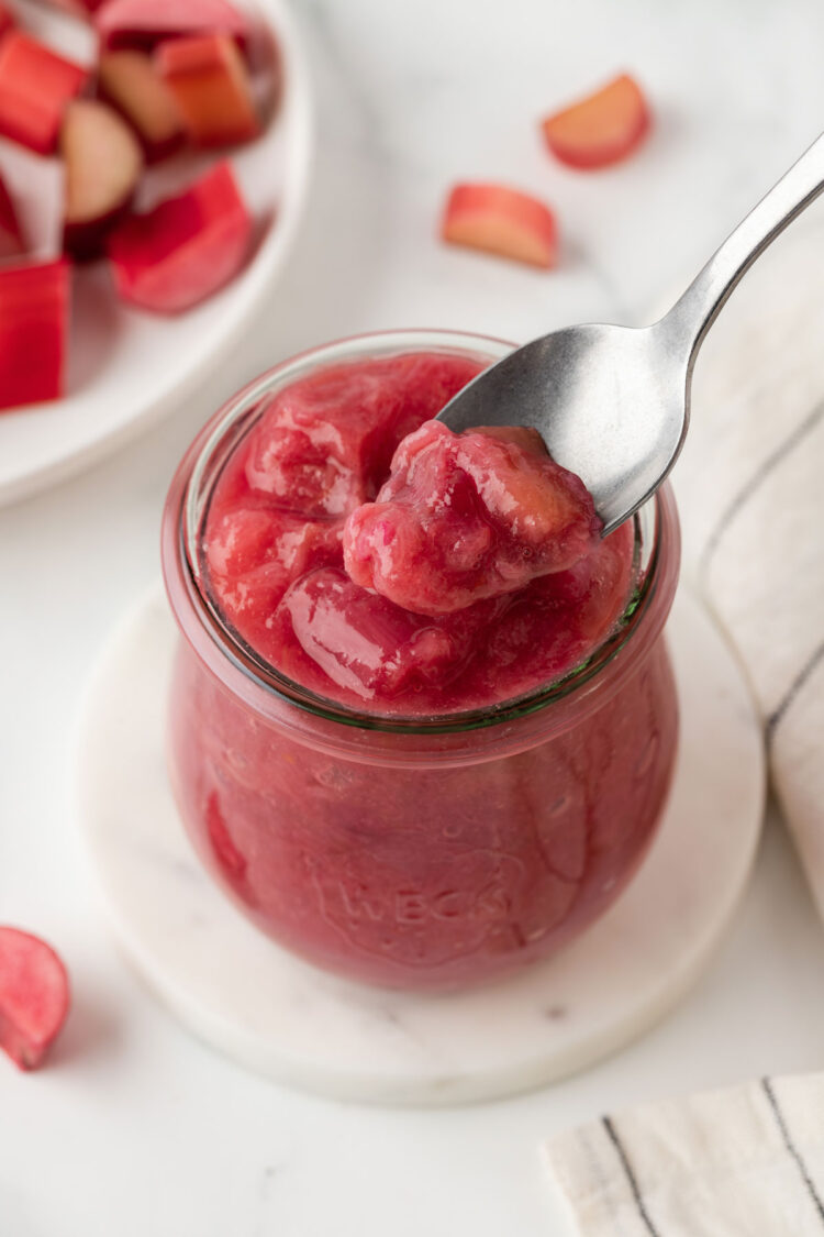 spoon digging into a glass of rhubarb compote