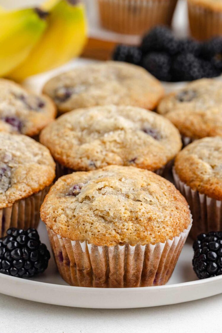 banana blackberry muffins on a white plate on white table