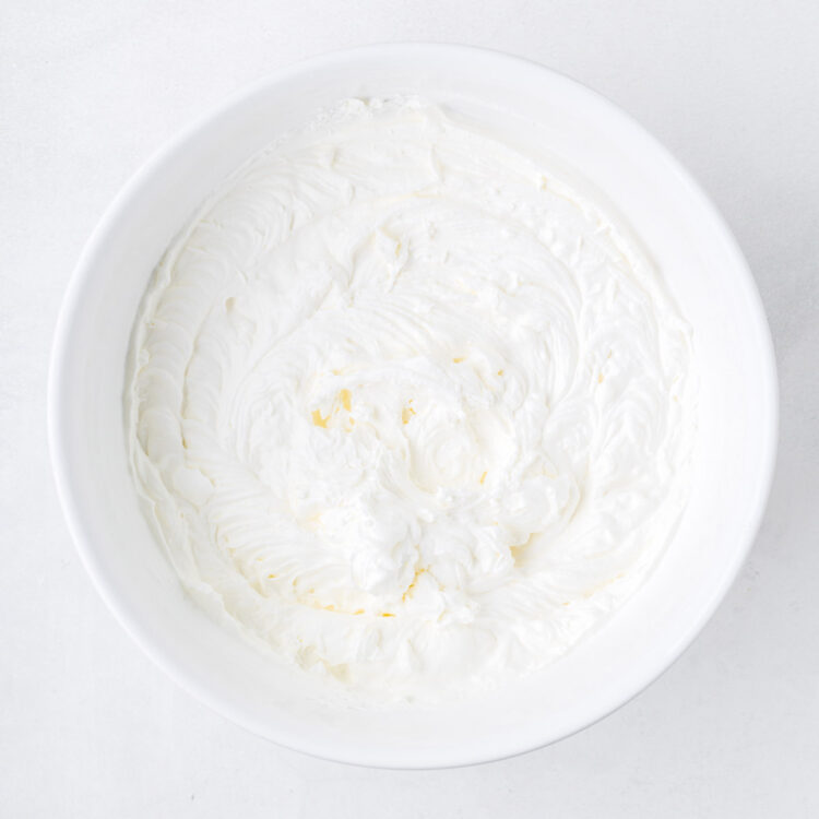 whipped cream in a white bowl on a white table