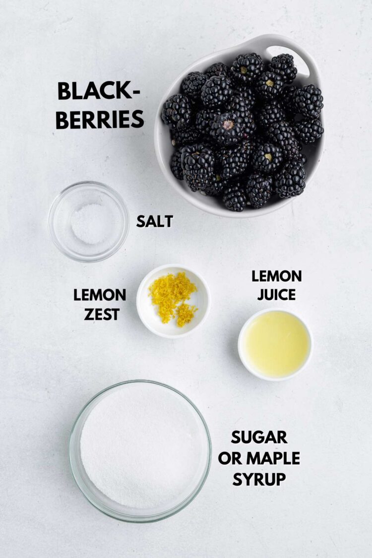 ingredients laid out to make blackberry jam on a white table