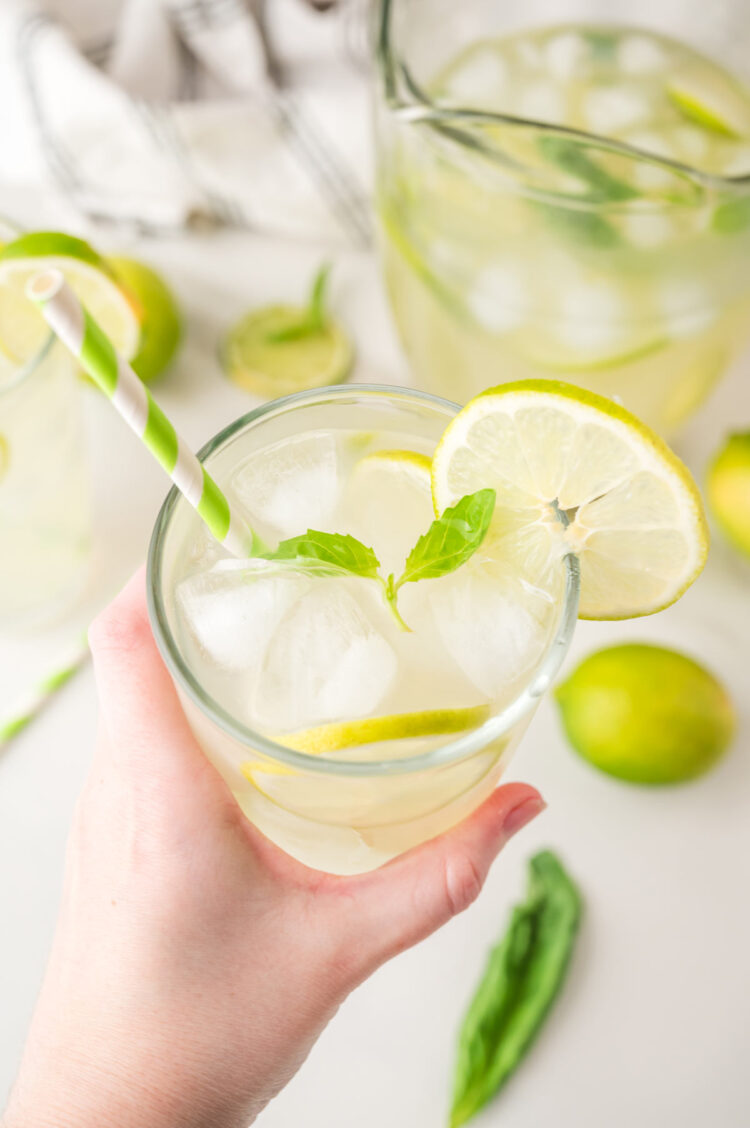 hand holding a glass of basil limeade