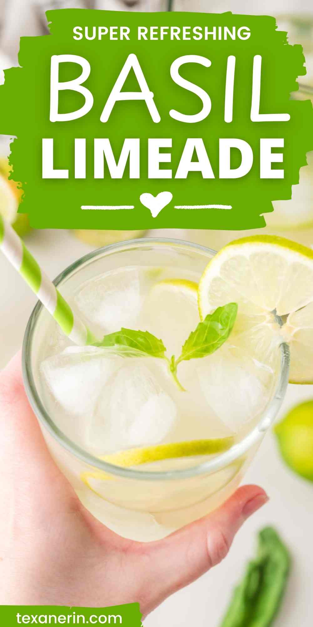 pin image for basil limeade showing a hand holding a glass with basil leaves and ice in it