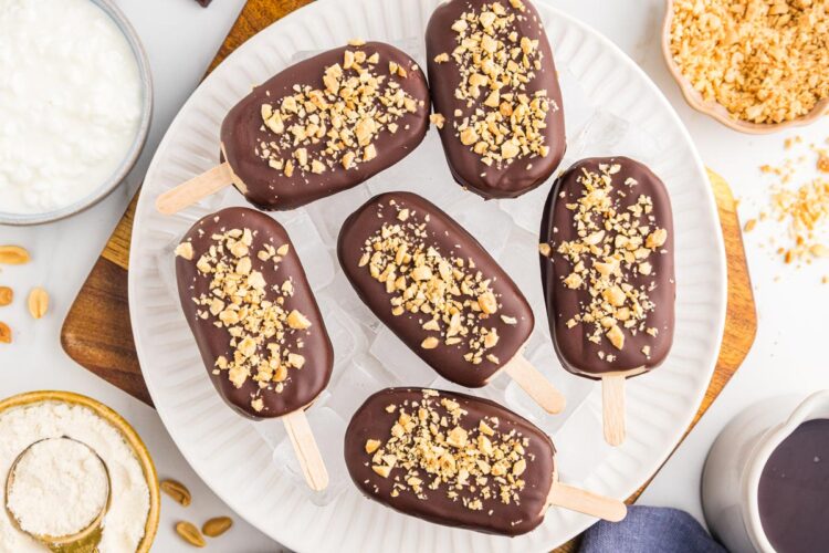 chocolate-covered protein ice cream bars resting over a bowl of ice