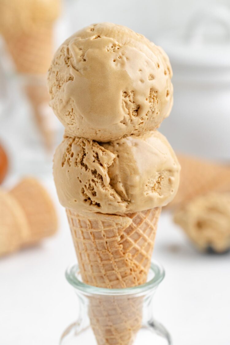 2 scoops of butterscotch ice cream in an ice cream cone