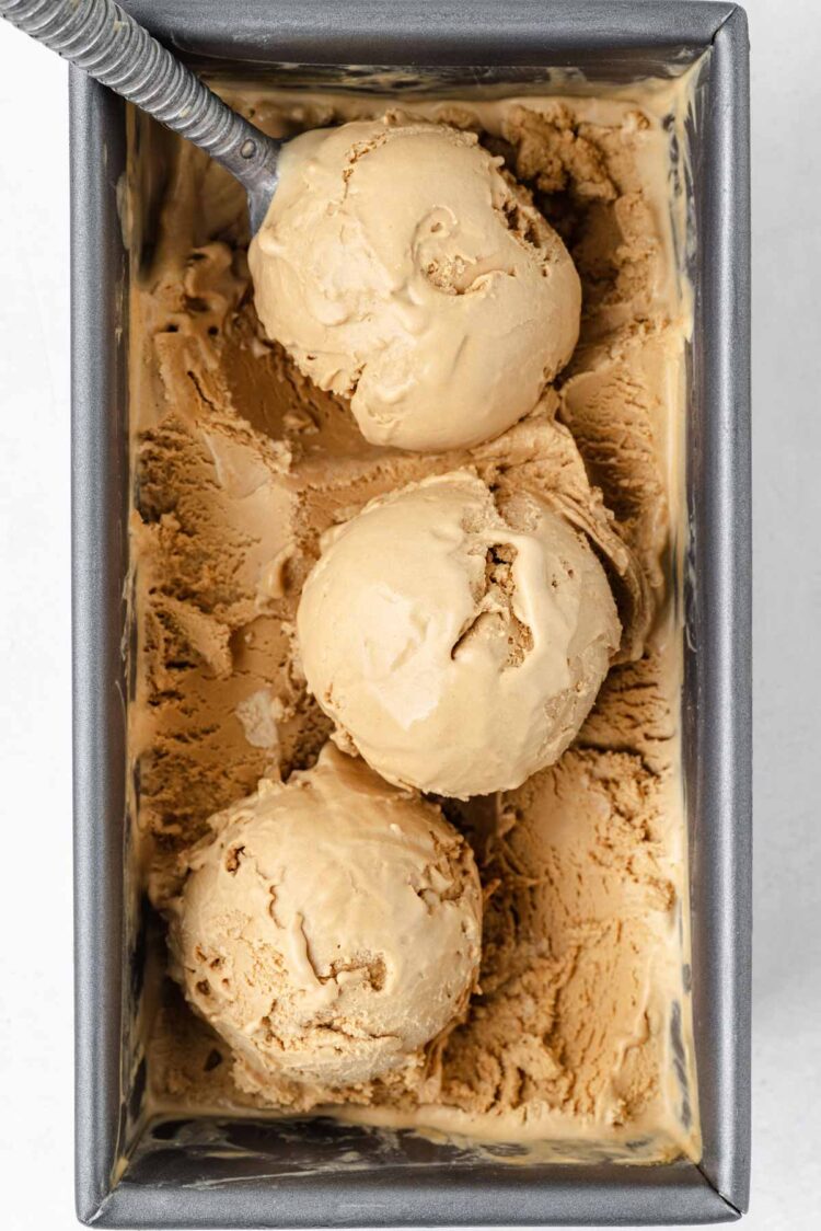 loaf pan filled with butterscotch ice cream and 3 scoops scooped out