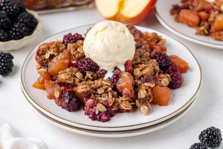 ice cream on a plate of apple blackberry crumble